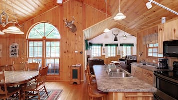 L'intérieur d'une cabane en bois comprend un coin repas, une cuisine et un espace de vie.