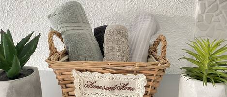 Una cesta de mimbre con toallas y una etiqueta que dice 'Home Sweet Home'.