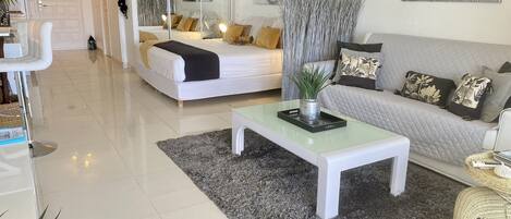 A modern living room with a bed, sofa, and a coffee table.