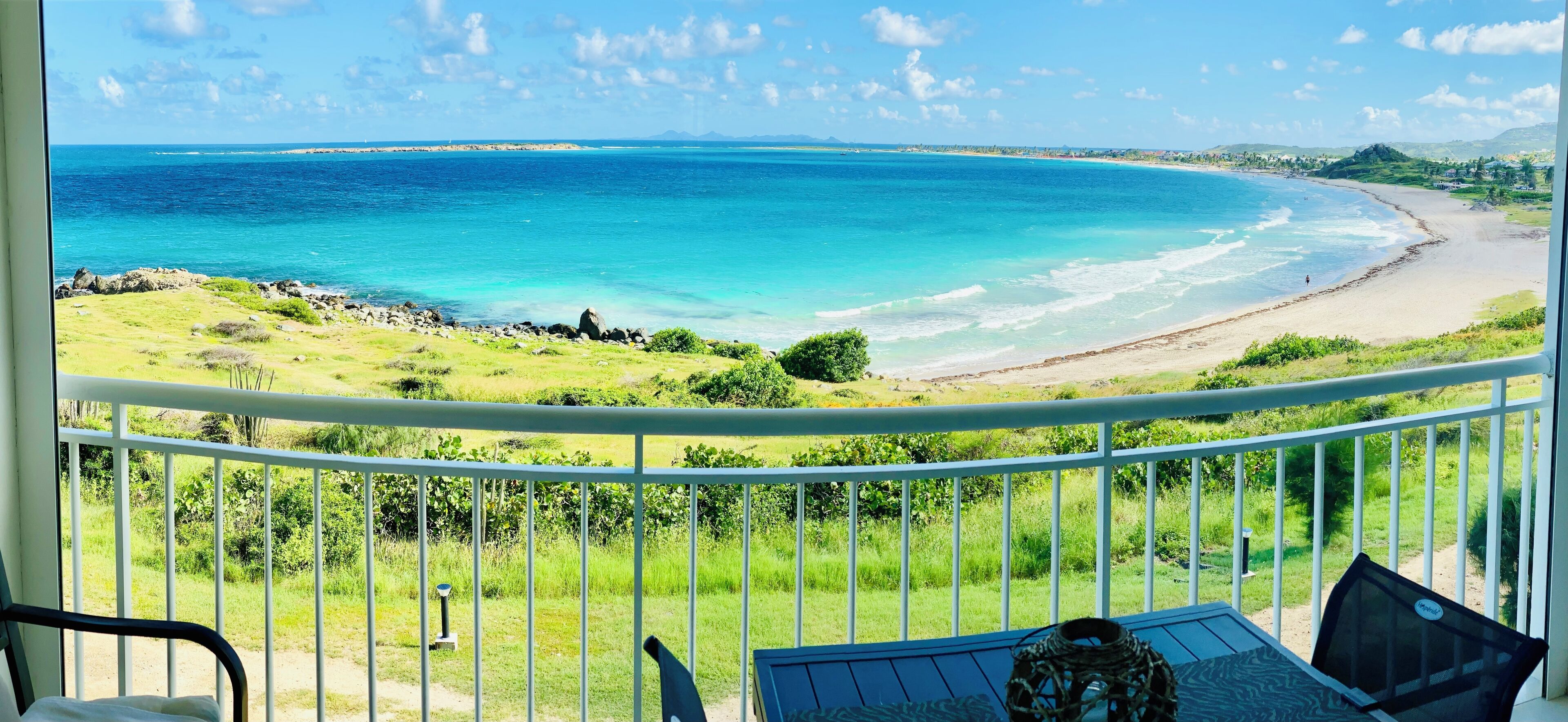A balcony with a view of a beach and ocean.