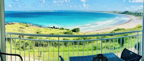 A balcony with a view of a beach and ocean.