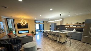 Una cocina moderna con una isla central, taburetes de bar y un horno empotrado.