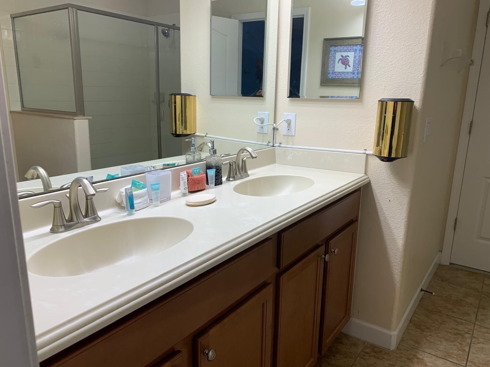 A bathroom with two sinks, a large mirror, and wooden cabinets.