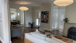 A modern living room with a sofa, dining area, and fireplace.