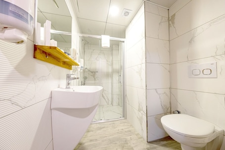 Quarto standard | Banheiro | Chuveiro, chuveiro com efeito de chuva, produtos de toalete grátis . Madeen City Hotel