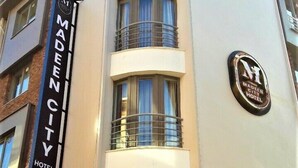Ein Gebäude mit einem Schild für 'Madeen City Hotel' und einem 'Cafe Restaurant' darunter.