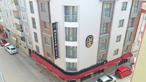 Un hotel de varios pisos con un llamativo letrero que dice 'MADEEN CITY HOTEL' en la fachada.