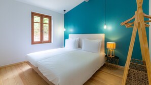Un dormitorio con una cama grande, una ventana, una lámpara y una estructura de madera.