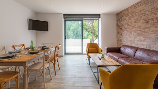 Un comedor moderno con una mesa de madera, sillas y un sofá.