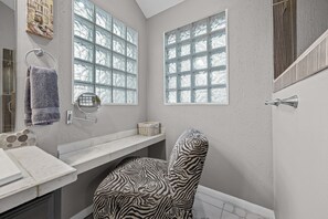 A bathroom with a bathtub, a towel rack, and a window with frosted glass.