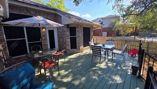 Una terraza con mobiliario exterior, una mesa y sillas.