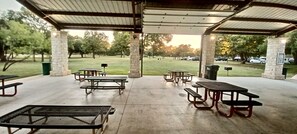 Un pabellón al aire libre con mesas de picnic y un pilar de piedra.