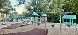 Ein Spielplatz mit Klettergerüsten, Rutschen und Schaukeln.