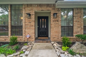Residential building with a garden and a black front door.