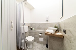 Eenvoudige kamer | Badkamer | Een douche, handdoeken, toiletpapier