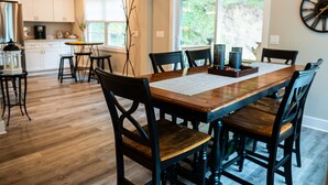 Un comedor con una mesa de madera, sillas negras y un centro de mesa decorativo.