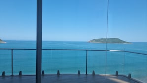 Ein Balkon mit freiem Blick auf das Meer und eine kleine Insel.