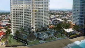 Ein Hochhaus-Hotel mit mehreren Balkonen, einem Poolbereich und Blick auf den Strand.