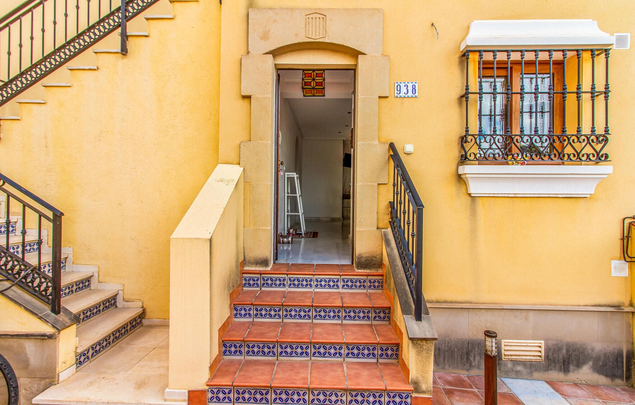 A staircase leading to a door with a number plate '938'.