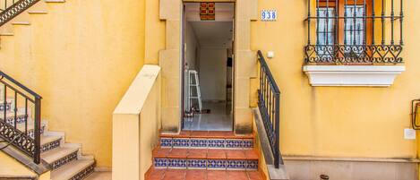 A staircase leading to a door with a number plate '938'.