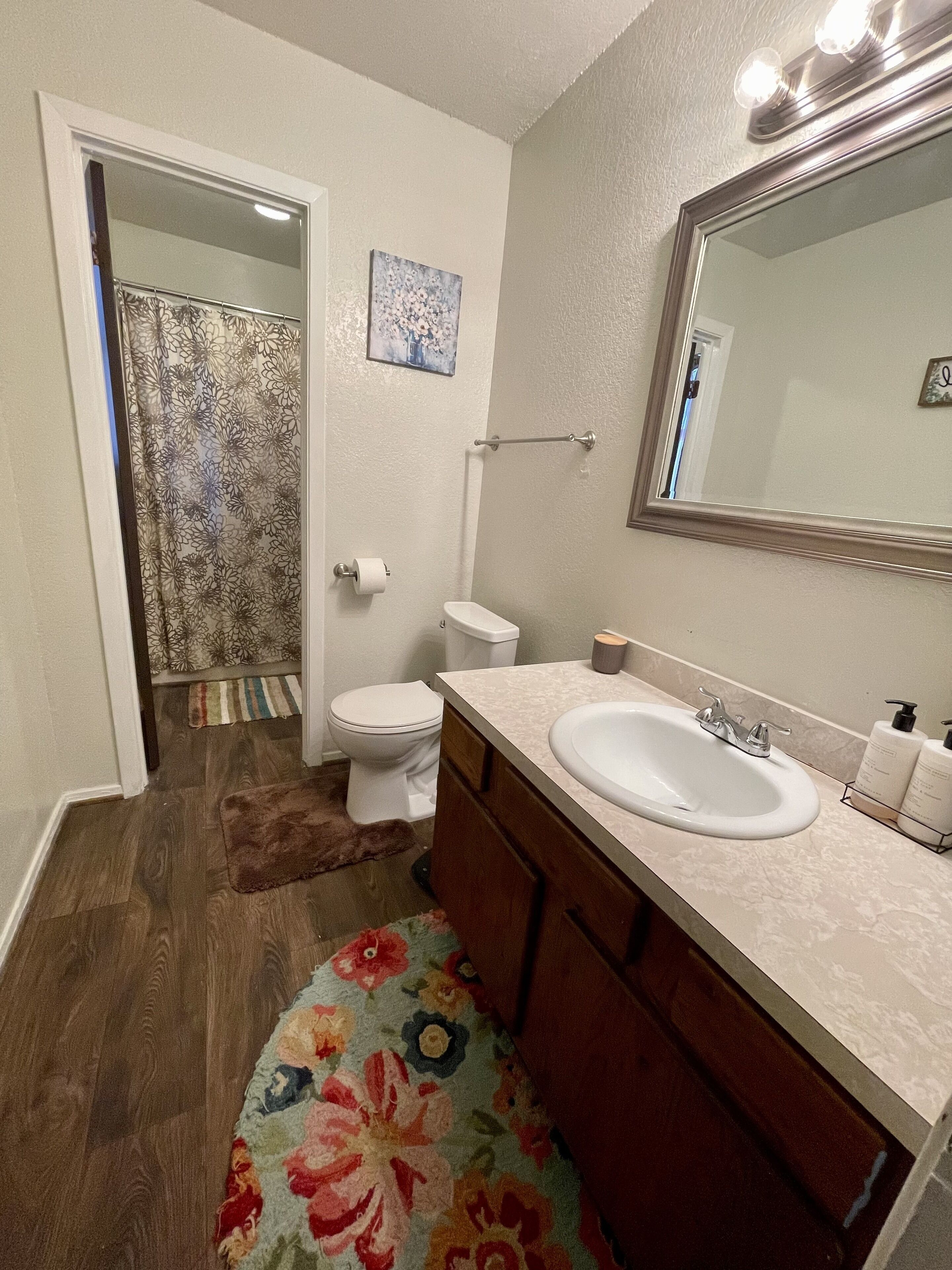 A bathroom with a toilet, sink, and shower.