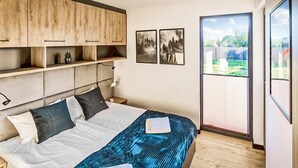 A bedroom with a bed, a headboard, a nightstand, a window, and a view of the outdoors. - Stunning home in Nowecin with kitchen (Nowecin)
