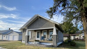 Uma casa térrea com varanda frontal, garagem e pequeno jardim.