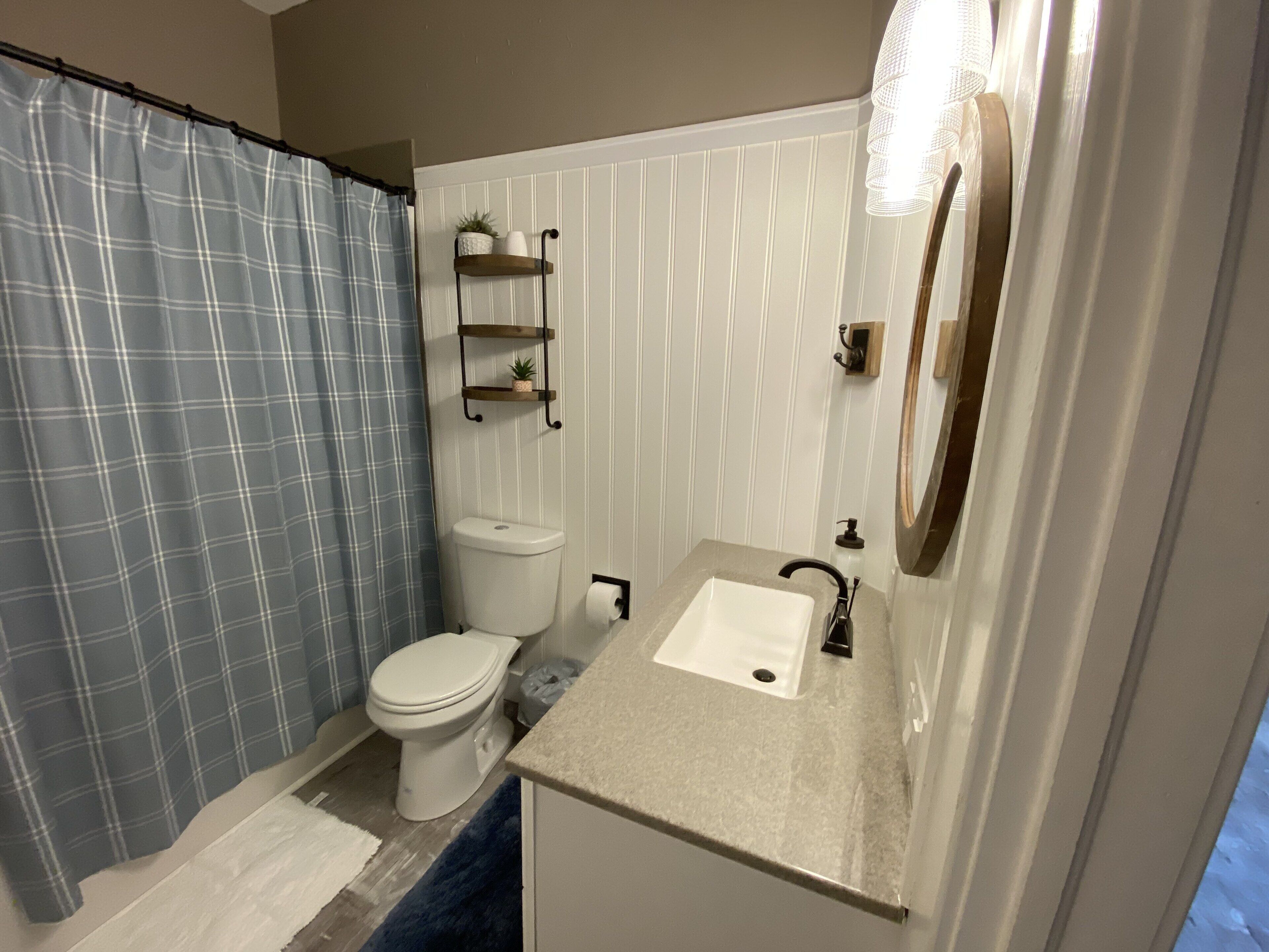 Tina con regadera, toallas, papel de baño 