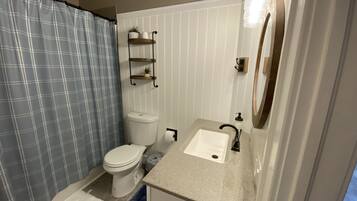 Tina con regadera, toallas, papel de baño