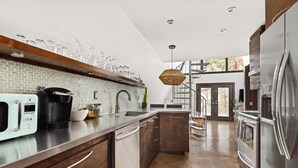 Eine moderne Küche mit integriertem Geschirrspüler, einer Kaffeemaschine und einem Edelstahl-Kühlschrank.