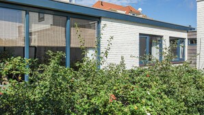 Un bâtiment moderne doté de grandes fenêtres, d’un toit plat et d’une façade en briques blanches.