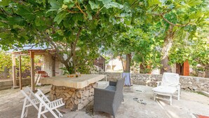 An outdoor patio with stone seating, a table, and a pergola. - 1 bedroom beautiful apartment in Vir (Vir)