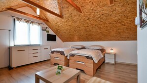 A cozy attic bedroom with a sloped ceiling, wooden furniture, and a small bedside table with a lamp. - Cozy home in Biskupec Zelinski with sauna (Biskupec Zelinski)