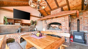 A rustic interior with a brick fireplace, wooden furniture, and a television mounted on the wall. - Amazing home in Nova Diklenica with sauna (Nova Diklenica)
