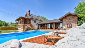 A two-story house with a swimming pool, a wooden deck, and a covered patio area. - Amazing home in Nova Diklenica with sauna (Nova Diklenica)