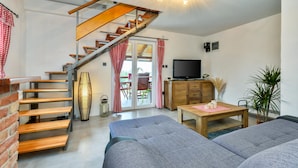 A cozy living room with a staircase, a television, and a dining area. - Amazing home in Nova Diklenica with sauna (Nova Diklenica)