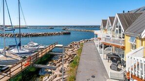 A marina with boats docked, a wooden walkway, and a building with a balcony overlooking the water. - Beach front home in Hasle (Hasle)