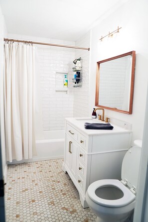 A bathroom with a white sink, a toilet, and a shower curtain. - The Village House - 3 bedroom, 1 bath home 1.5 mi to Texas A&M, 2 mi to Legends (Bryan)