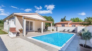 A house with a swimming pool, outdoor seating, and a brick oven. - Lovely home in Valbandon (Valbandon)