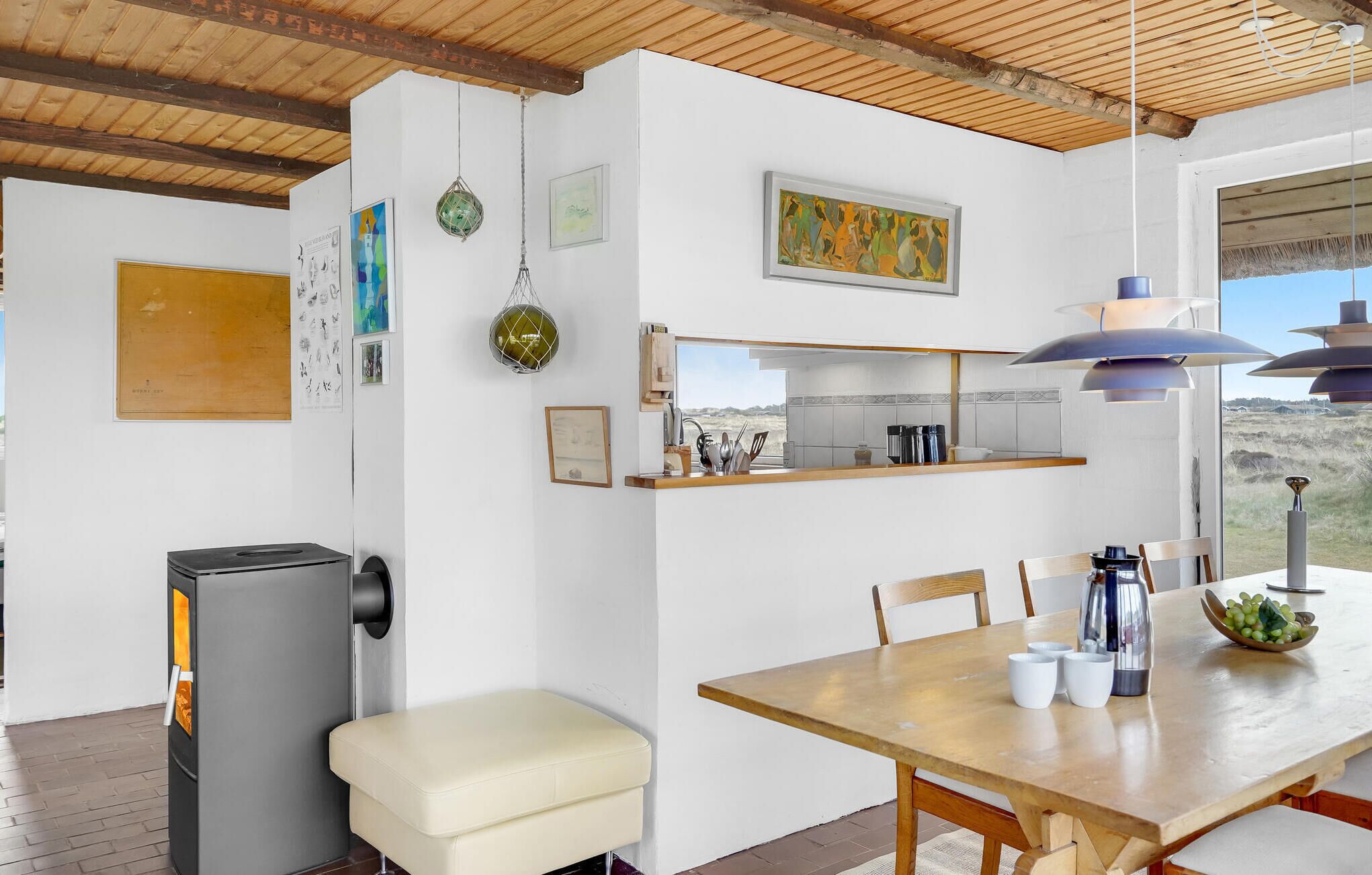 Une cuisine moderne avec un coin repas, comprenant une table en bois, des chaises, un réfrigérateur et divers ustensiles de cuisine.