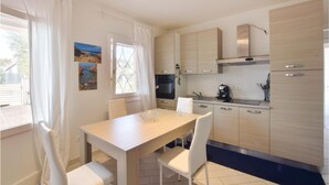 A modern kitchen with light wood cabinets, a built-in oven, and a coffee maker on the counter. - Lovely home in Valledoria with WiFi (Valledoria)