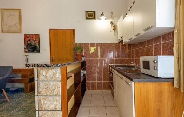 A compact kitchen with a microwave, sink, and wooden cabinets. - Gorgeous apartment in Vir with WiFi (Vir)