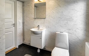 Un baño con una puerta blanca, un lavabo, un espejo y un inodoro.