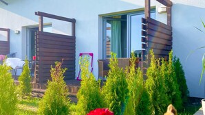 A modern building with a balcony, a chair, and a table. - 2 bedroom nice home in Grzybowo (Grzybowo)