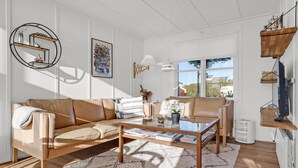 A modern living room with a sofa, coffee table, and a TV stand. - Amazing home in Ebeltoft with sauna (Ebeltoft)