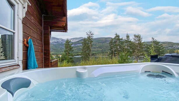Un bain à remous avec vue sur les montagnes et les arbres.