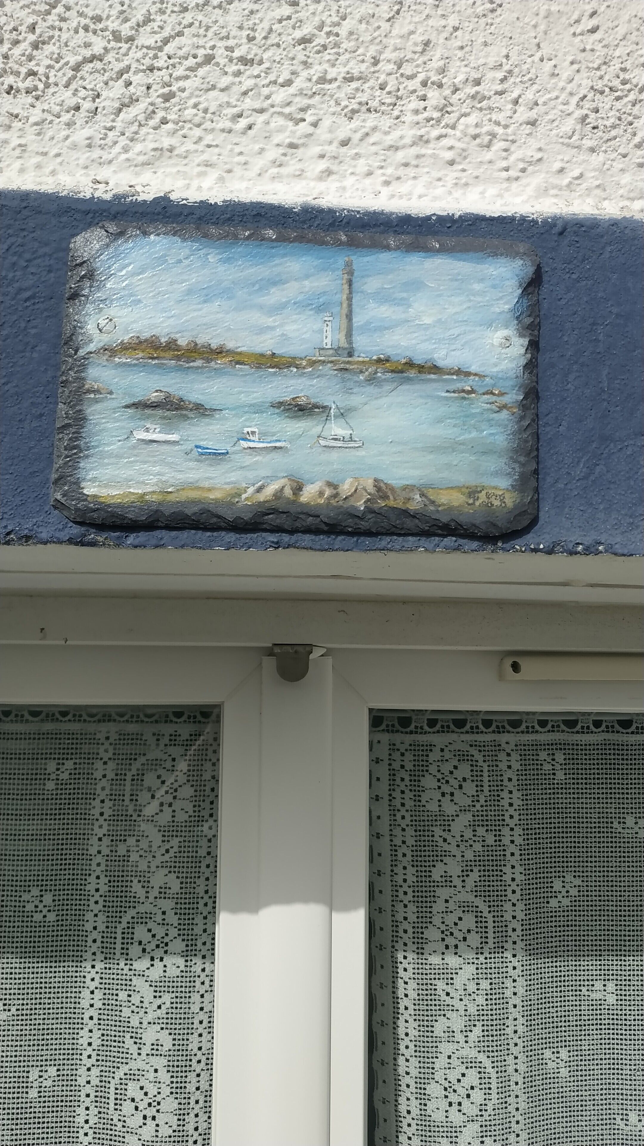 A coastal scene with a lighthouse, boats, and rocky outcrops.
