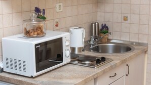 Une cuisine équipée d’un four à micro-ondes blanc, d’une machine à café et d’un évier.