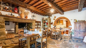 A rustic interior with a stone fireplace, wooden furniture, and a stone floor. - Cozy home in Castiglion Fiorentino (Castiglion Fiorentino)