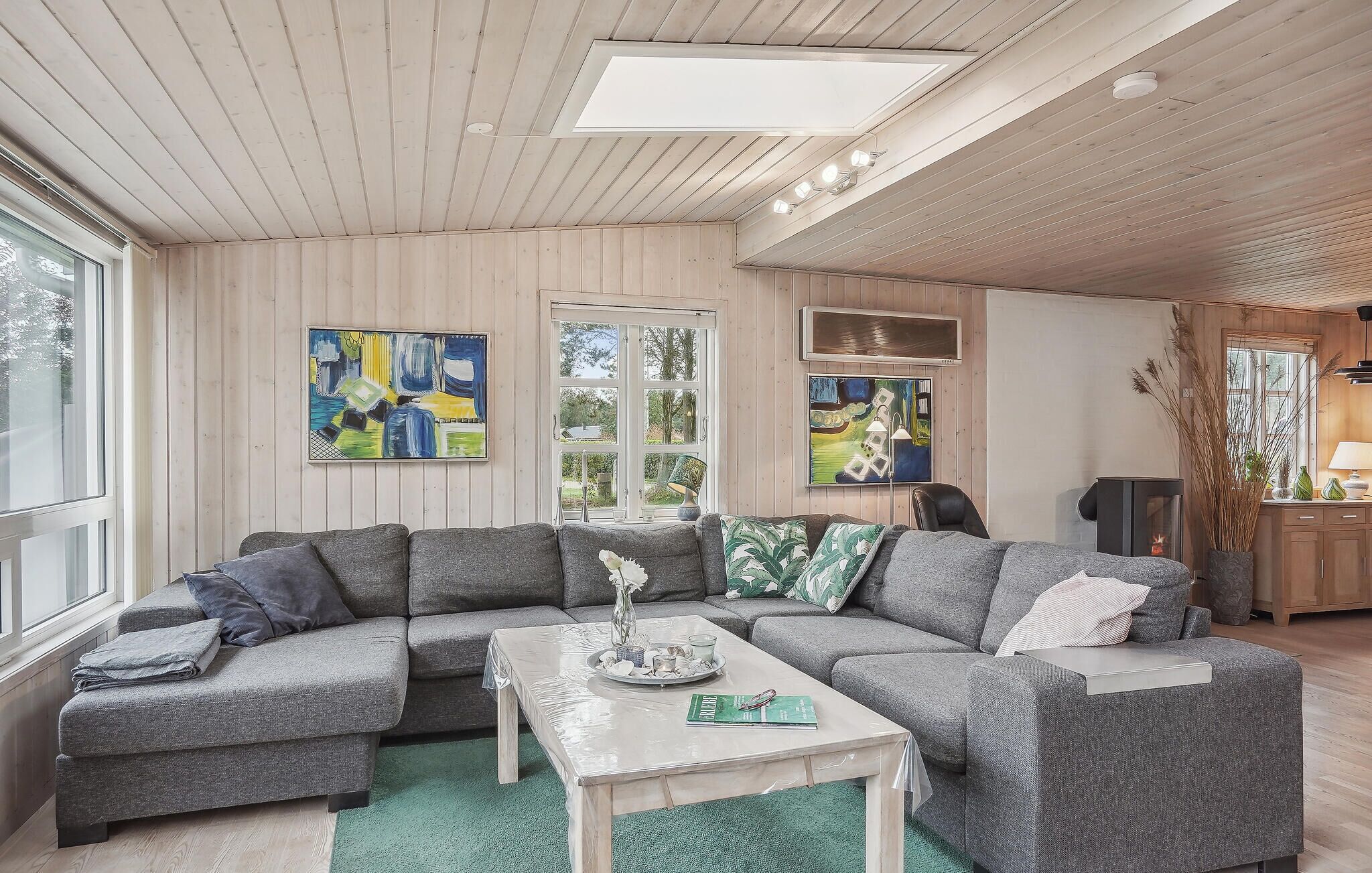 A modern living room with a sectional sofa, a coffee table, and artwork on the walls.